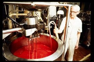 Man standing nest to a large vat of red liquid