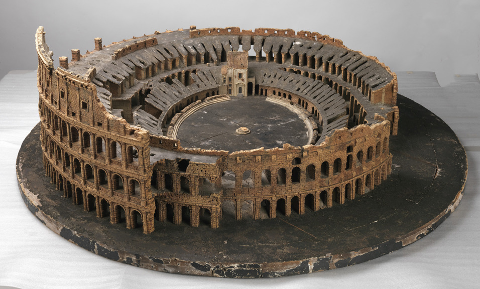 a cork model of a round tiered colosseum missing some parts