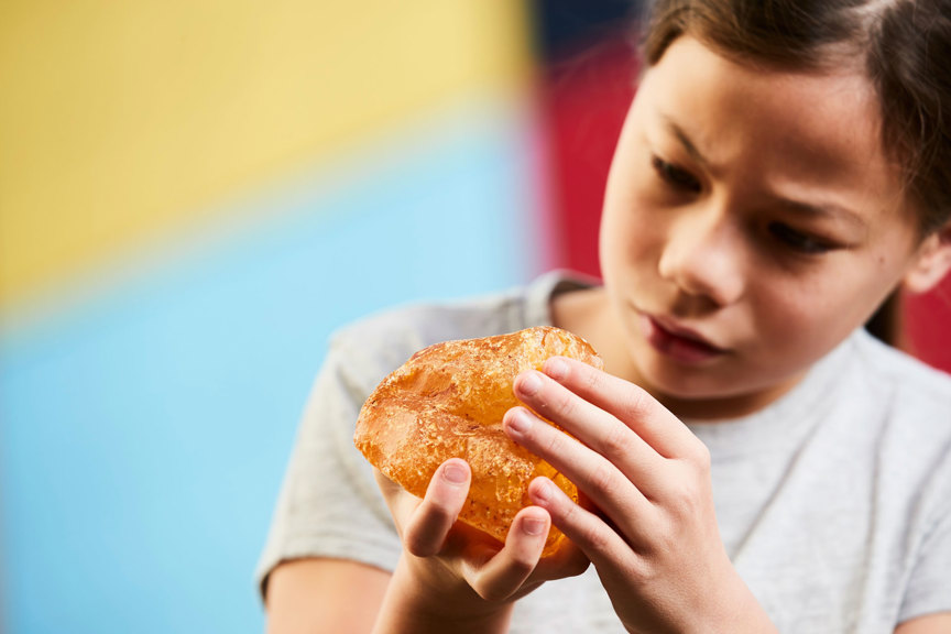 Girl looking closely at a crystal