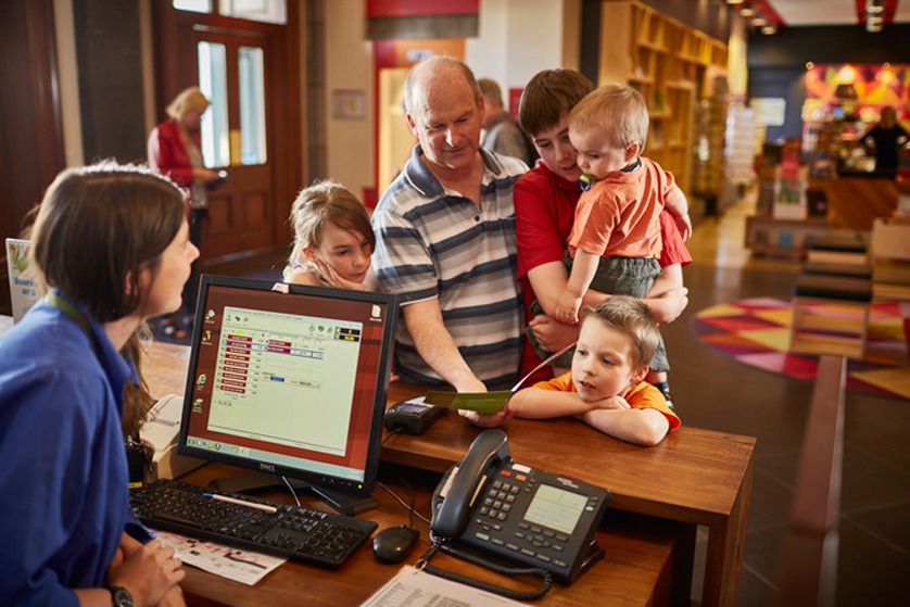 Family at the ticketing desk at the Immigration Museum.