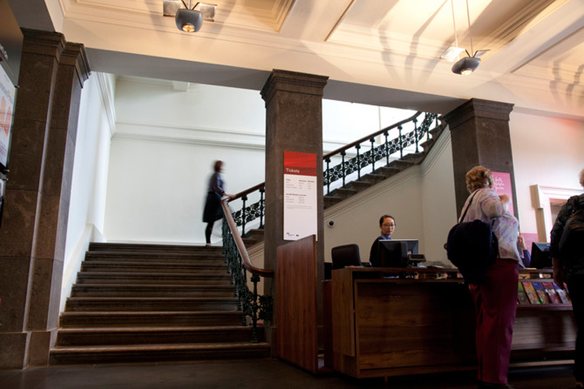 Woman on staircase leading up from the Immigration Museum foyer.