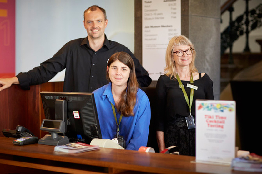 Various Museum staff at the ticketing desk at Immigration Museum.