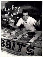 Man looking through window with "It's a boy, 10lb 6oz, you beaut" written on it