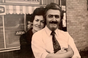 Woman standing behind and embracing man.