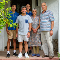 Three adults and two children standing on veranda