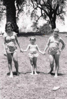 Three girls in swimmers holding hands