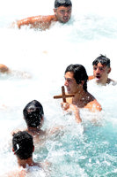 A young swimmer in the water holding a cross 