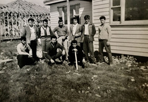 Group of men posed outside a weatherboard house