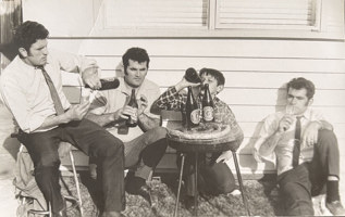 Four men drinking outside.