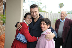 A handsome man posing with two children
