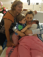 Woman holding baby in hospital bed.