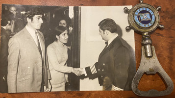 Photo of woman shaking hand of captain, held in place by bottle opener.