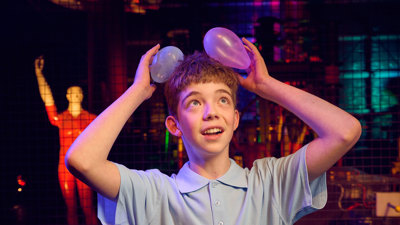  A Child attaches small balloons to their hair using static electricity in the Lightning Theatre at Scienceworks.