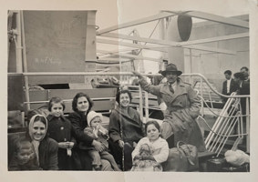 Photo of eight people of various ages with suitcases