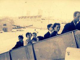 Eight people of varying ages walking up gangway.
