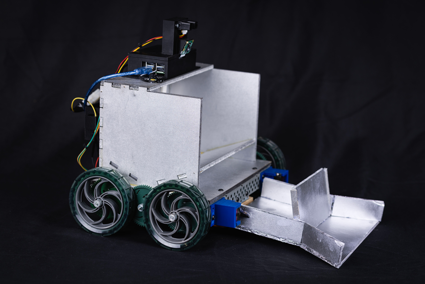 A photograph of a silver system with wheels, a black battery and wires. 