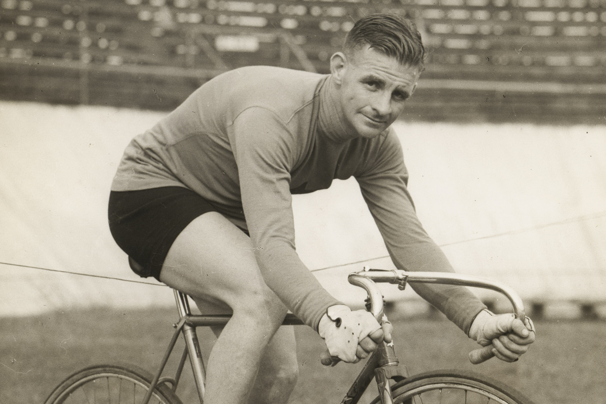 a sepia image of a man riding a bicycle