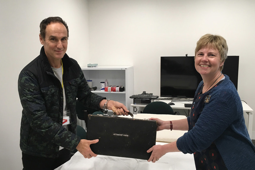 a man and a woman holding a briefcase between them