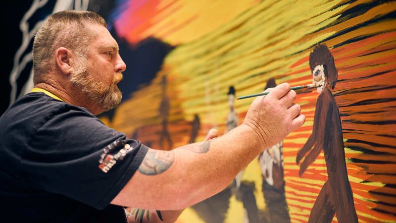 Man painting an artwork on a wall