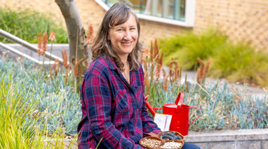 A woman sits with a bowl on her lap