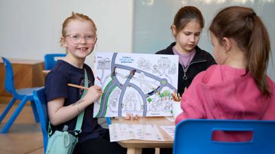 Children with craft materials and road maps at the activity, lower ground floor outside the Learning studios.