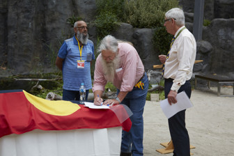 Three men signing papers