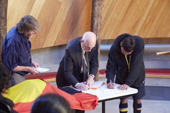Two men signing papers