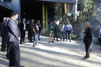 Group of people listen to a woman speaking