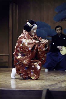 A woman on stage in traditional Japanese costume