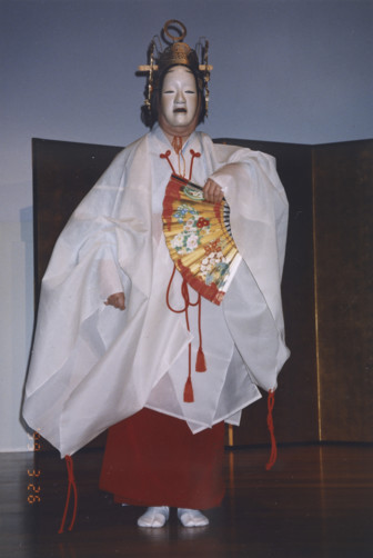 A woman on stage in traditional Japanese costume