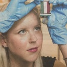 Woman wearing gloves holding a medal