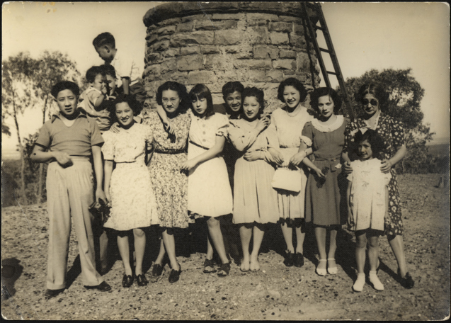 Gung family standing in front of stone wall and ladder. It was taken at Lake Mountain, circa 1930s-40s.  