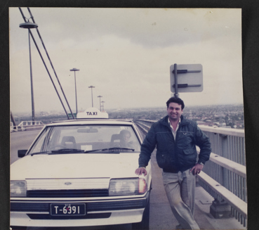 Portrait of taxi driver in front of his taxi on Westgate bridge, 1985.