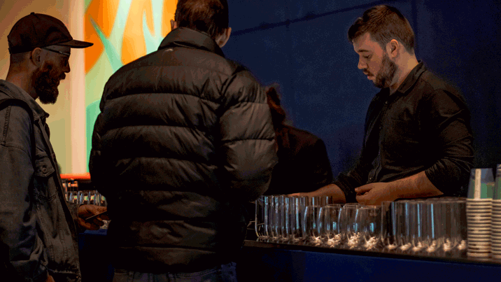 People grabbing drinking and food from the bar at Nocturnal, Melbourne Museum.