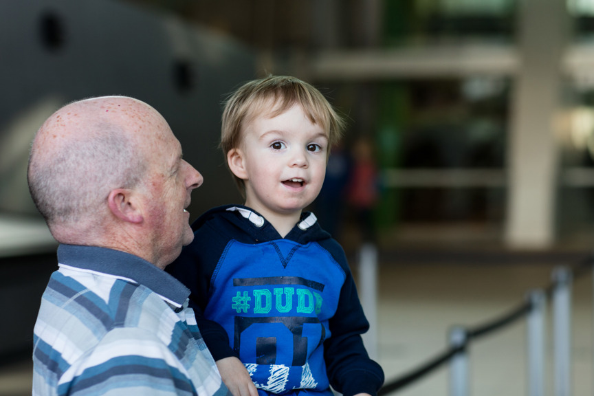 Father with toddler waiting in line to purchase tickets to enter the Melbourne Museum