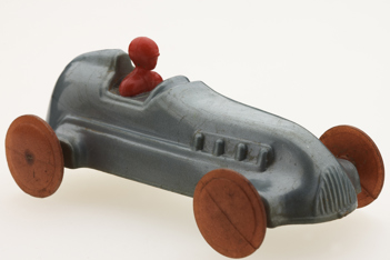 Grey car with orange wheels and red figure in driving seat.