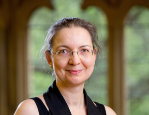 Portrait of woman in black clothing wearing glasses.