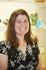 Woman in black and white dress in front of mineral display.