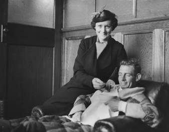 Man sitting in armchair with woman sitting alongside.