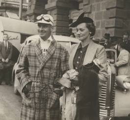 Man in dressing gown standing next to a woman.