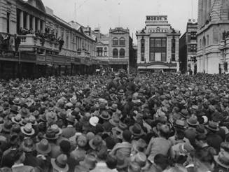Large crowd filling the street between buildings
