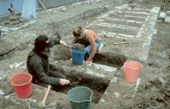 Two archaeologists digging pits