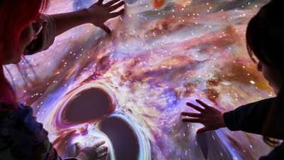 Two women stretching flexible video screen