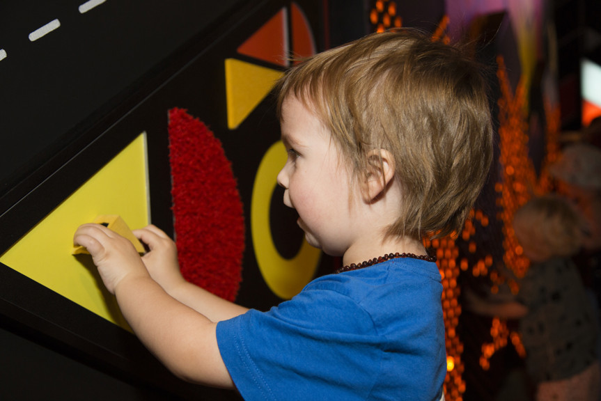 Boy playing with the Texture Wall interactive in Ground Up exhibition at Scienceworks.