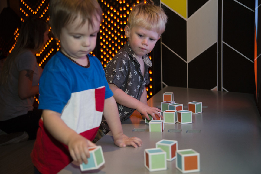 Boy playing with block shapes in Ground Up exhibition at Scienceworks.