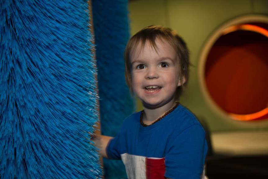 Boy touching soft blue brush interactive in Ground Up exhibition at Scienceworks. 