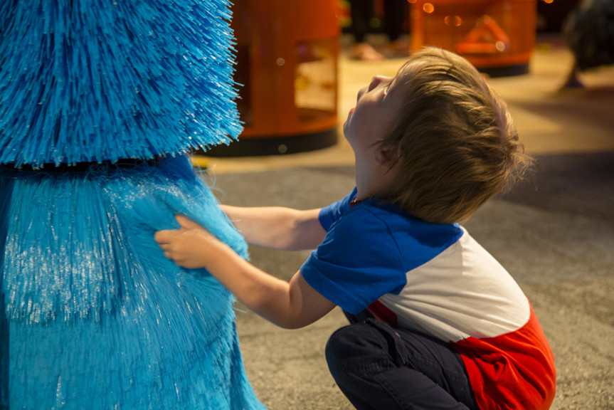 Boy touching soft blue brush interactive in Ground Up exhibition at Scienceworks. 