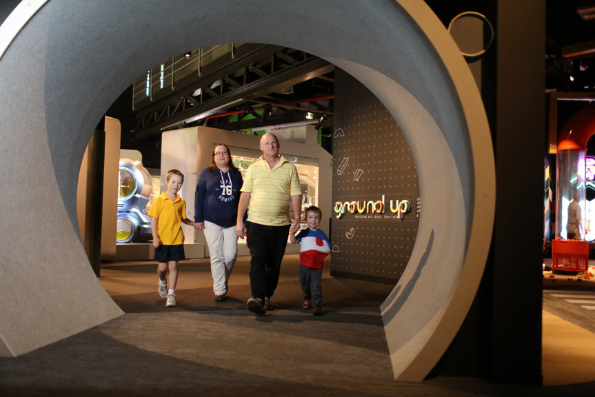 Family walking towards the entrance tunnel to the Ground Up exhibition at Scienceworks. 