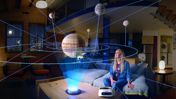 Woman sitting on a couch looking at a projected planetary system