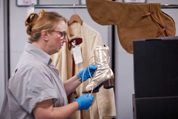 A woman looks at a gold boot